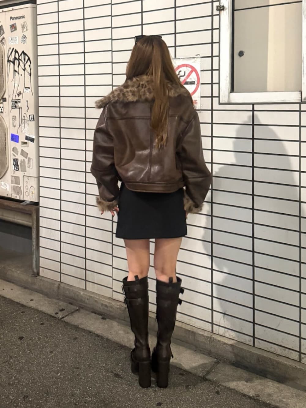 その他のムートンコート、ブラック系のスカート、ブラック系のブーツを着用したレディースの夏コーディネートの3枚目の写真