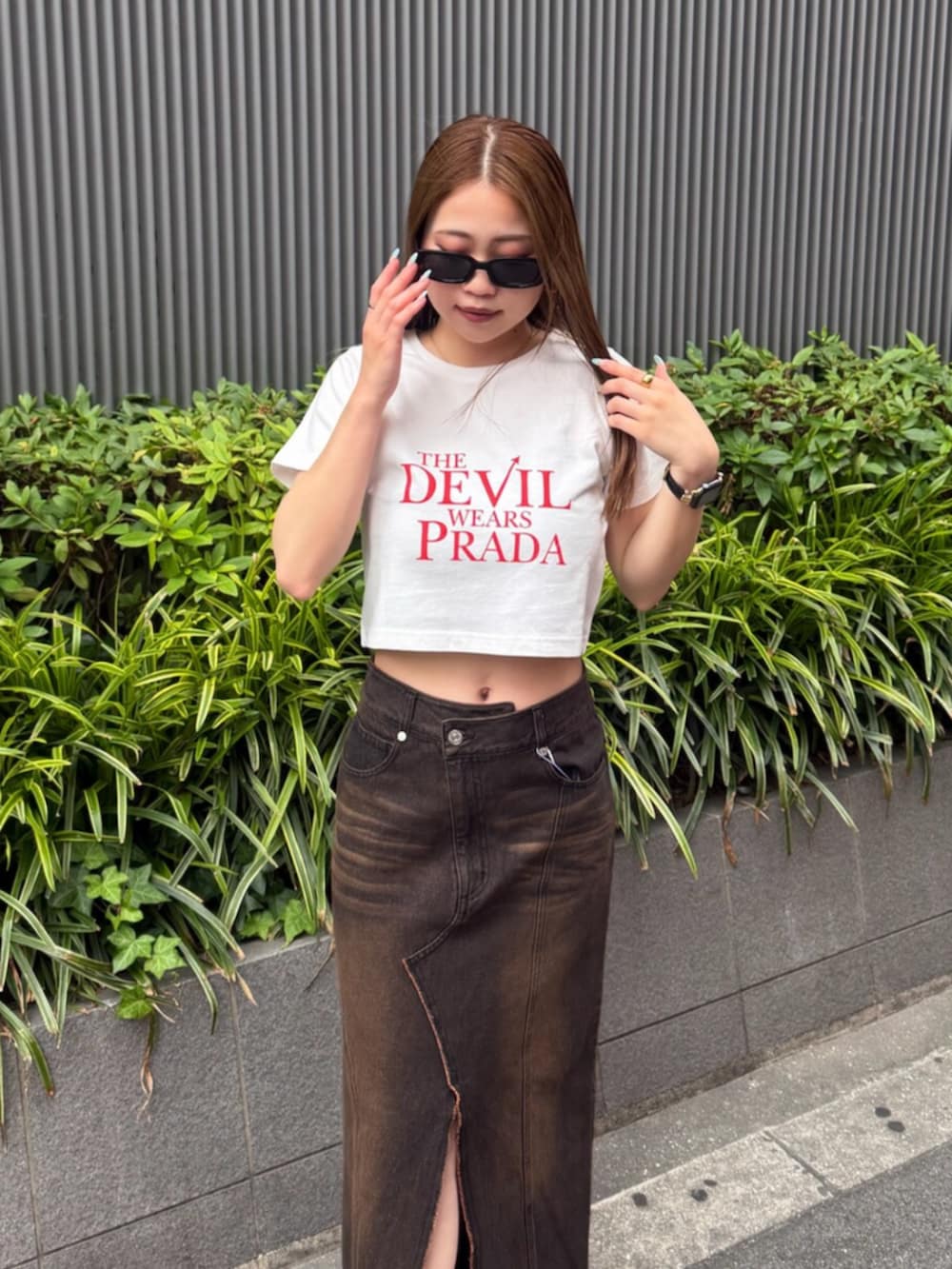 ブラック系のブーツ、ブラウン系のデニムスカート、ホワイト系のTシャツ/カットソーを着用したレディースの夏コーディネートの4枚目の写真