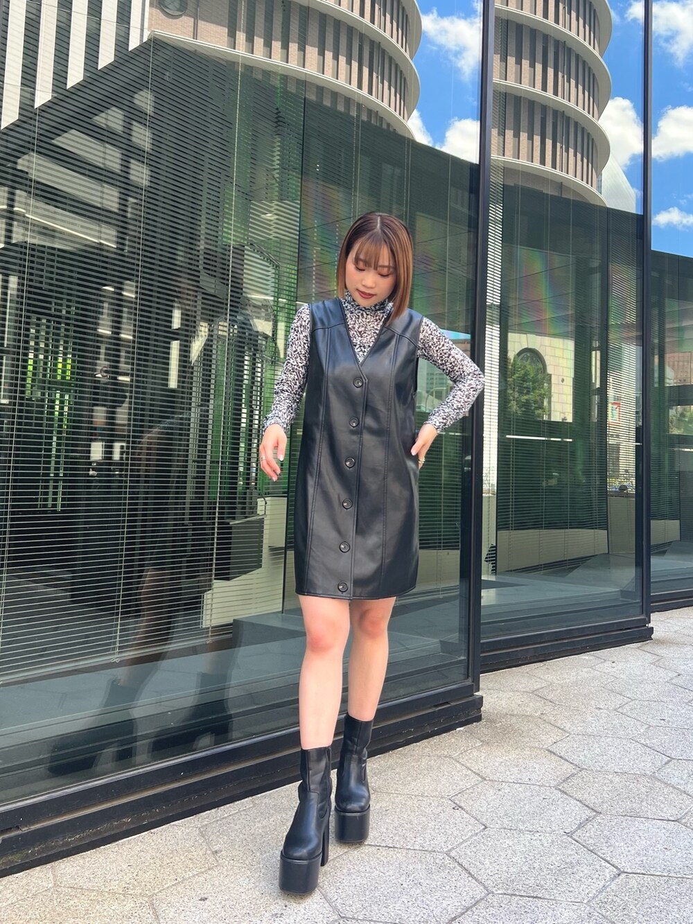 ホワイト系のTシャツ/カットソー、ブラック系のワンピース、ブラック系のブーツを着用したレディースの夏コーディネートの4枚目の写真