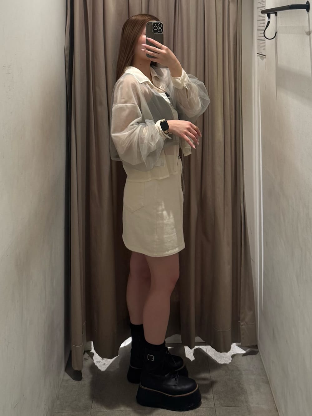 ホワイト系のデニムスカート、イエロー系のシャツ/ブラウス、ブラック系のブーツを着用したレディースの春コーディネートの2枚目の写真