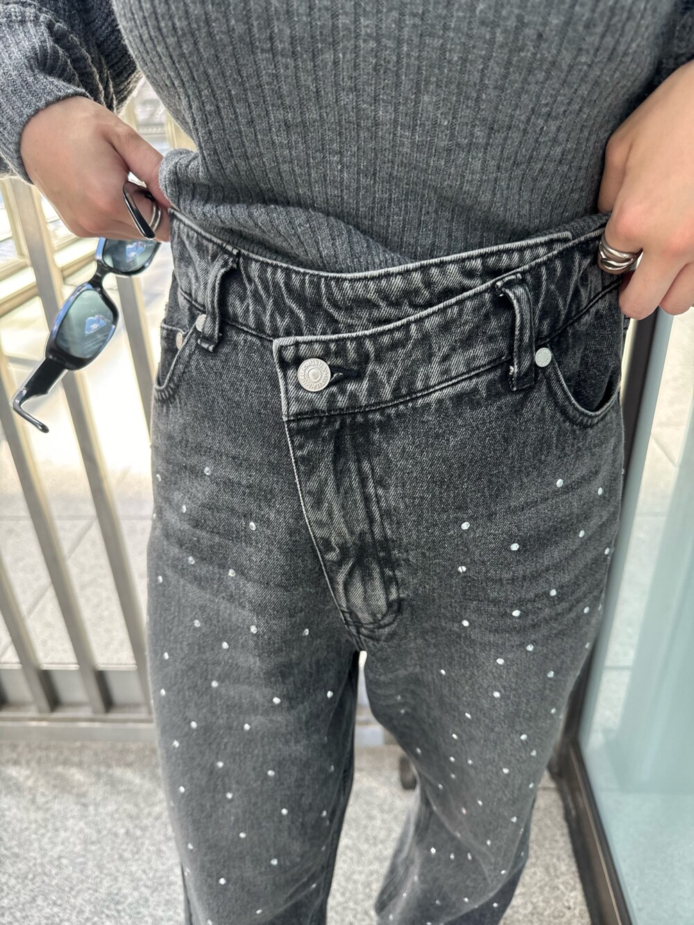 グレー系のニット/セーター、ブラック系のデニムパンツ、ブラウン系のブーツを着用したレディースの秋コーディネートの9枚目の写真