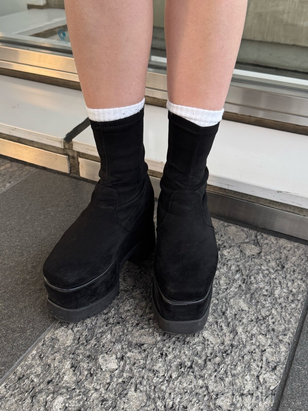 レッド系のニット/セーター、ブラウン系のスカート、ブラック系のムートンコートを着用したレディースの冬コーディネートの7枚目の写真