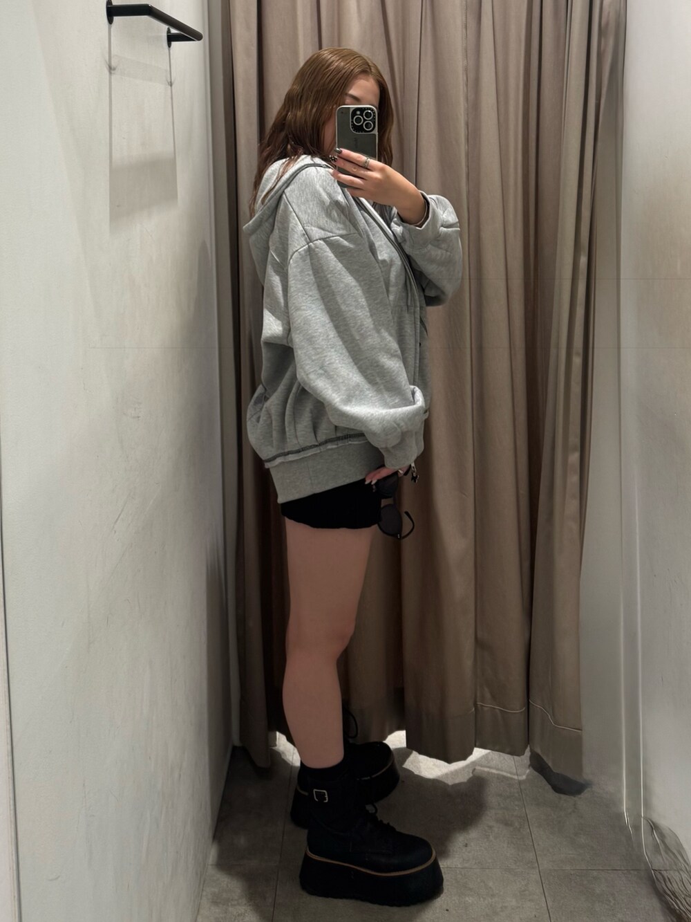 グレー系のパーカー、ブラック系のその他パンツ、ブラック系のブーツを着用したレディースの秋コーディネートの2枚目の写真