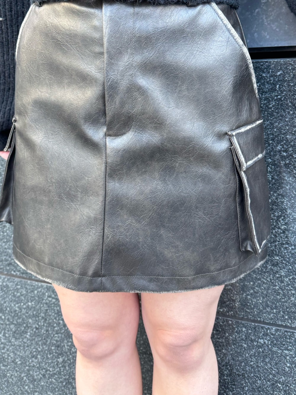 ホワイト系のニット/セーター、ブラウン系のスカート、ブラック系のブーツを着用したレディースの冬コーディネートの6枚目の写真