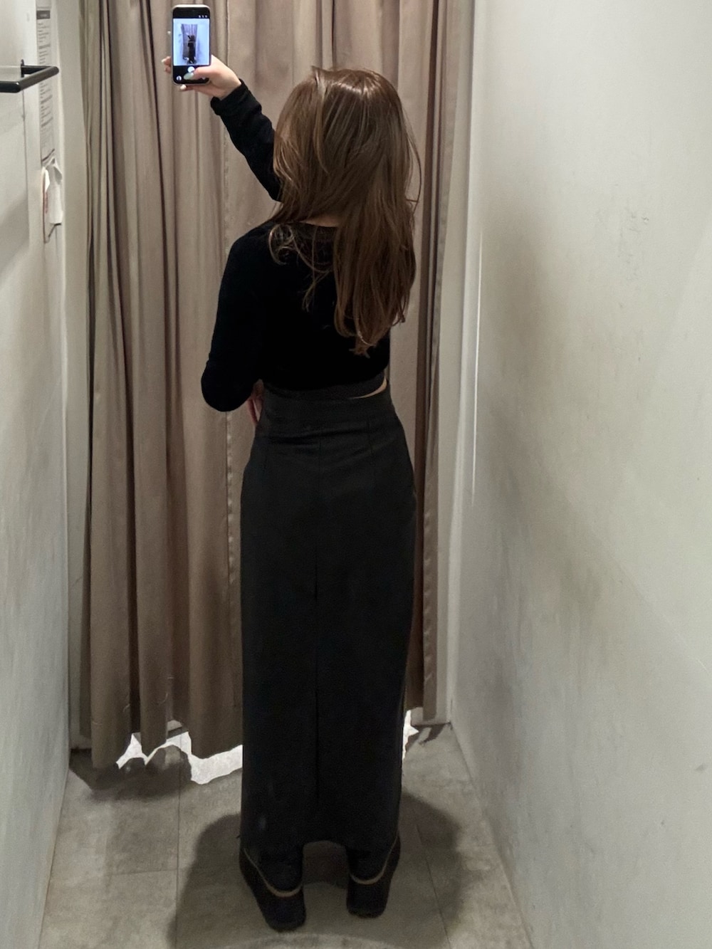 ブラック系のスカート、ブラック系のTシャツ/カットソー、ブラック系のブーツを着用したレディースの冬コーディネートの3枚目の写真