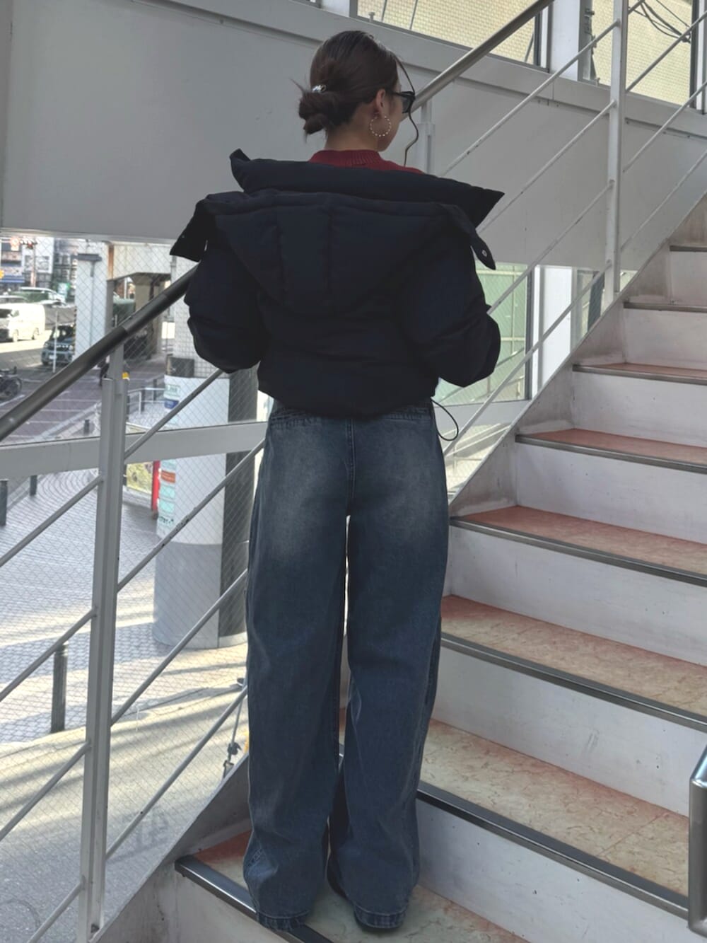 ブラック系のブーツ、ブルー系のデニムパンツ、レッド系のニット/セーターを着用したレディースの冬コーディネートの3枚目の写真