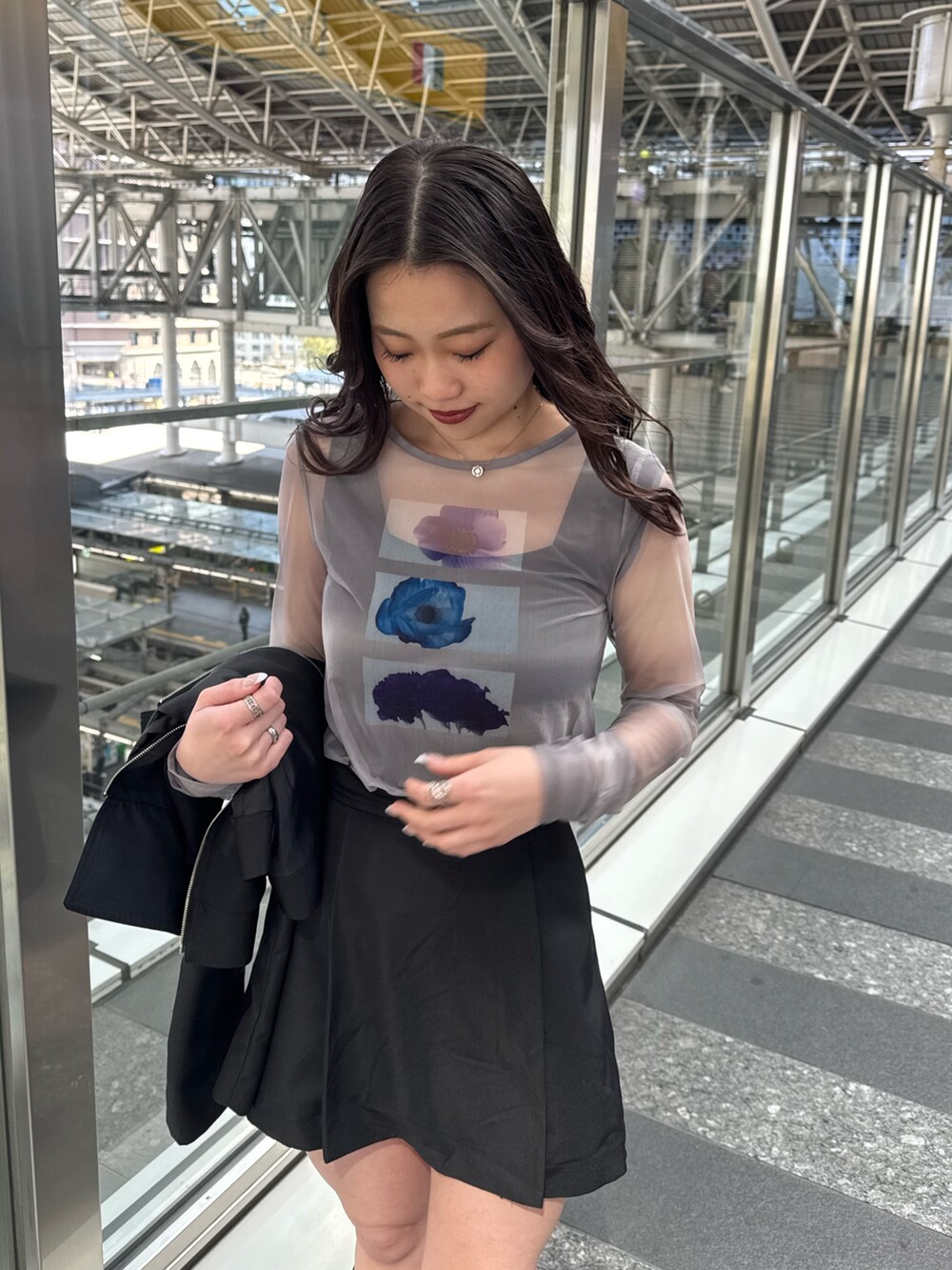 グレー系のTシャツ/カットソー、ブラック系のスカート、ブラウン系のブーツを着用したレディースの春コーディネートの4枚目の写真