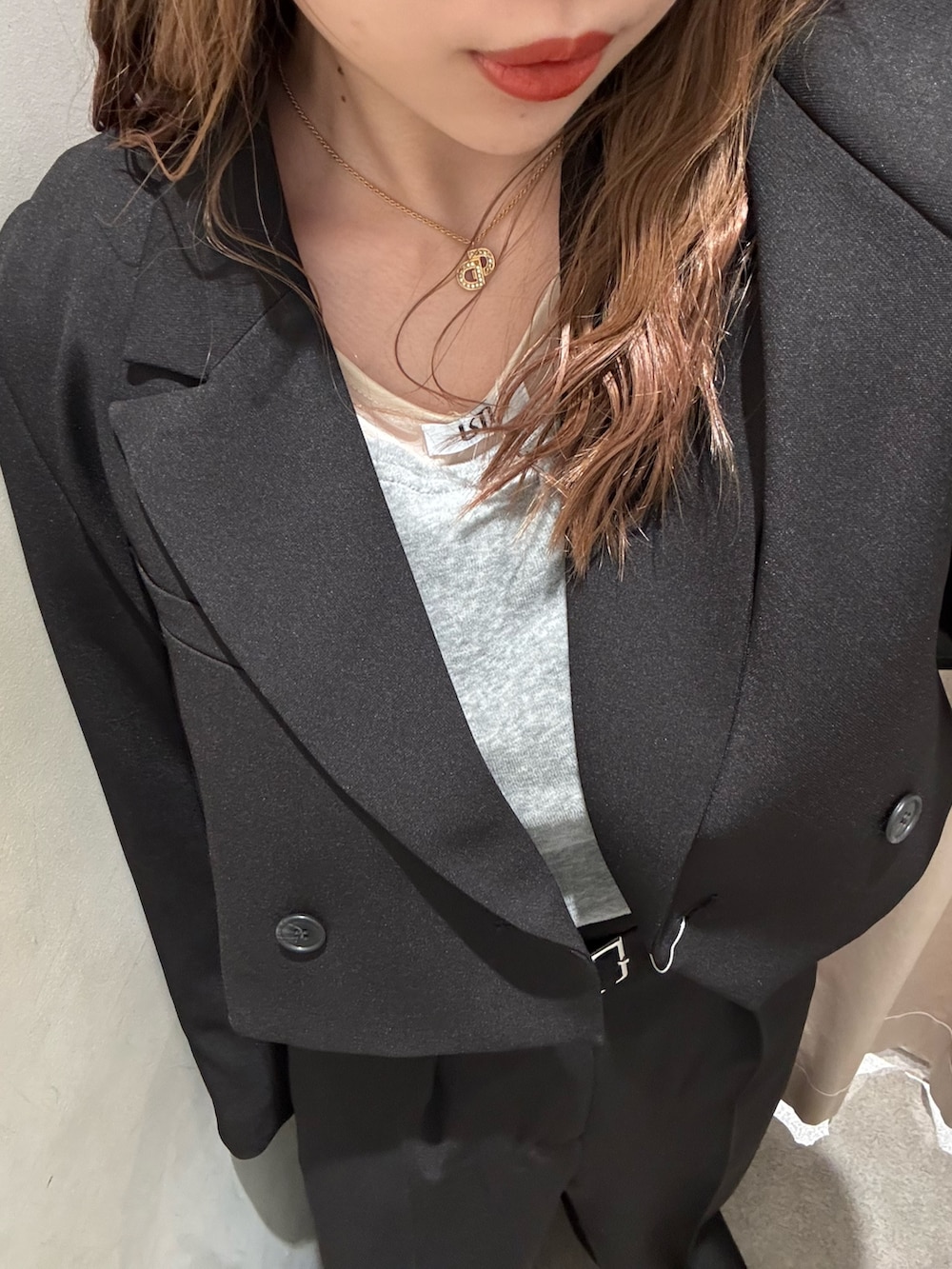 ブラック系のスラックス、ブラック系のテーラードジャケット、グレー系のTシャツ/カットソーを着用したレディースの冬コーディネートの5枚目の写真