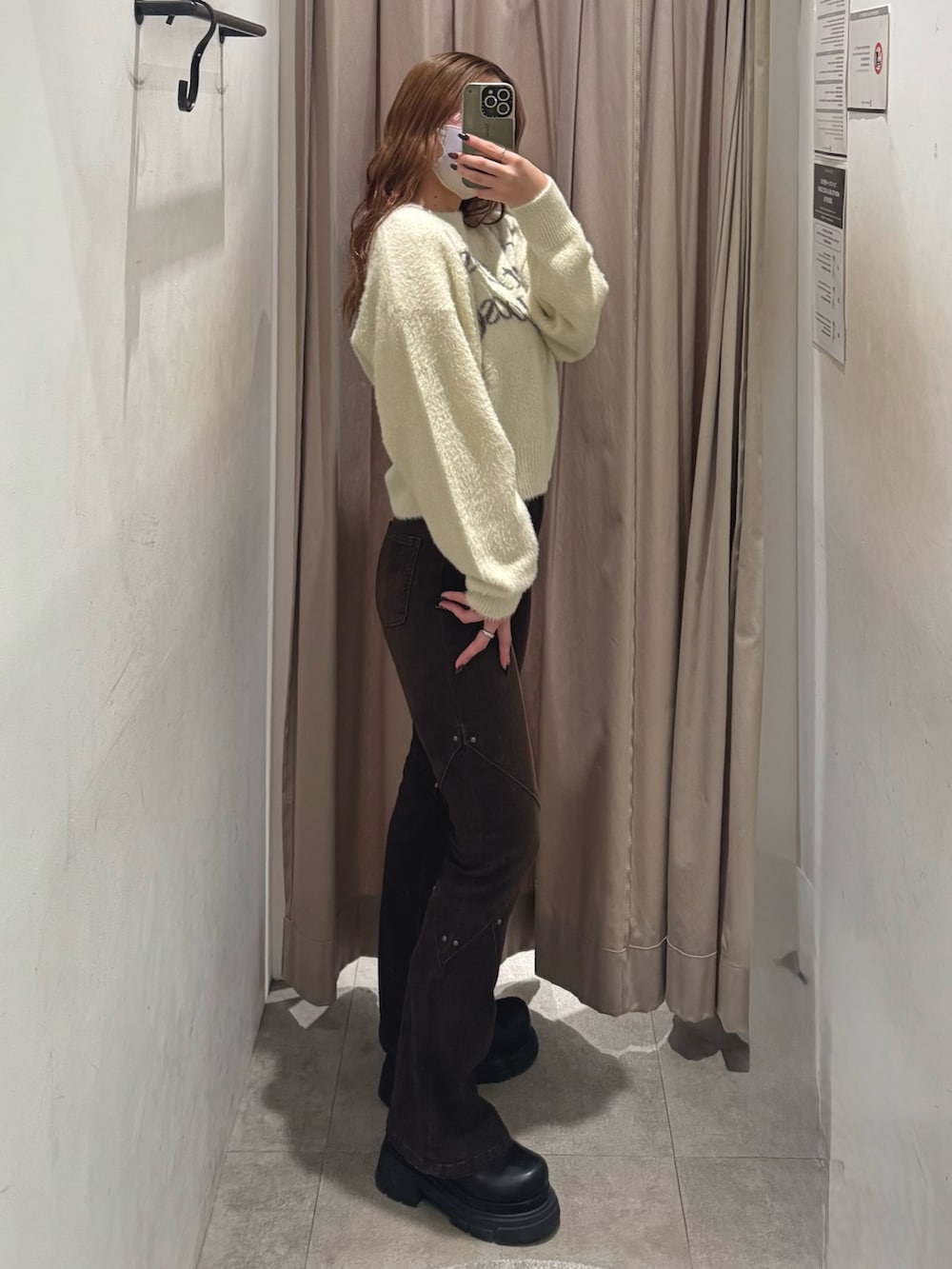 ホワイト系のニット/セーター、ブラウン系のデニムパンツ、ブラック系のブーツを着用したレディースの秋コーディネートの2枚目の写真