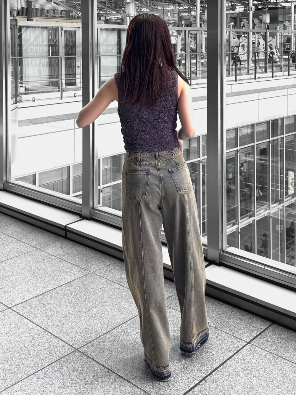 オレンジ系のタンクトップ、その他のデニムパンツ、ブラック系のサンダルを着用したレディースの春コーディネートの3枚目の写真