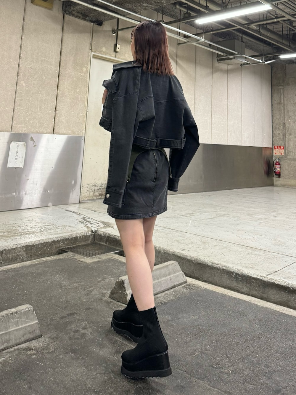 ブラック系のデニムジャケット、ブラック系のスカート、グリーン系のTシャツ/カットソーを着用したレディースの夏コーディネートの4枚目の写真