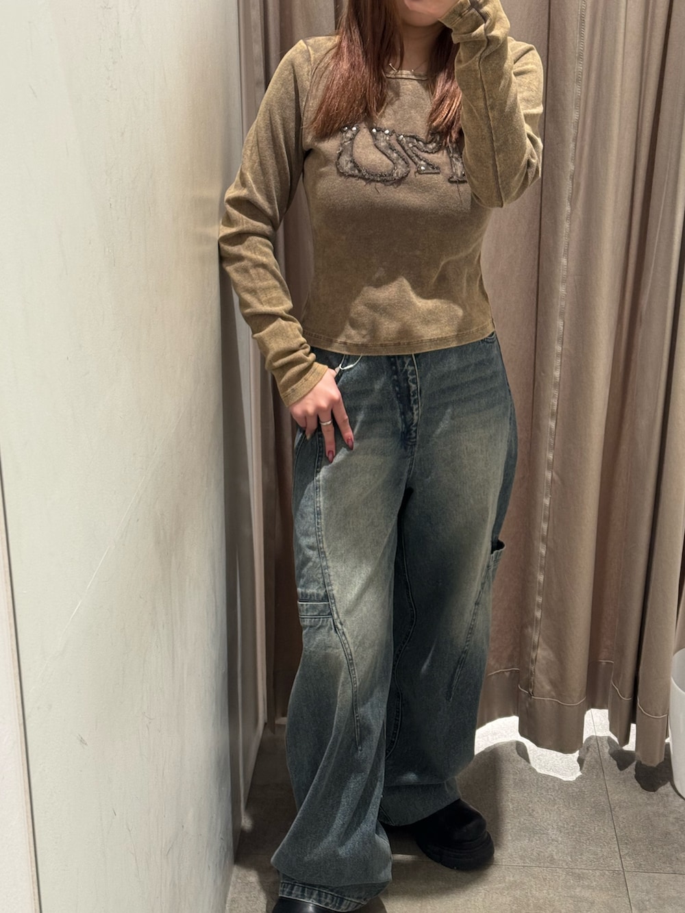 ブルー系のデニムパンツ、ブラウン系のTシャツ/カットソー、ブラック系のブーツを着用したレディースの冬コーディネートの5枚目の写真