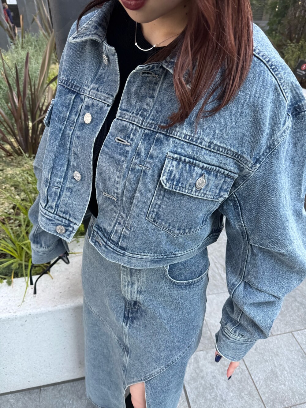 ブルー系のデニムスカート、ブルー系のデニムジャケット、ブラック系のニット/セーターを着用したレディースの冬コーディネートの6枚目の写真