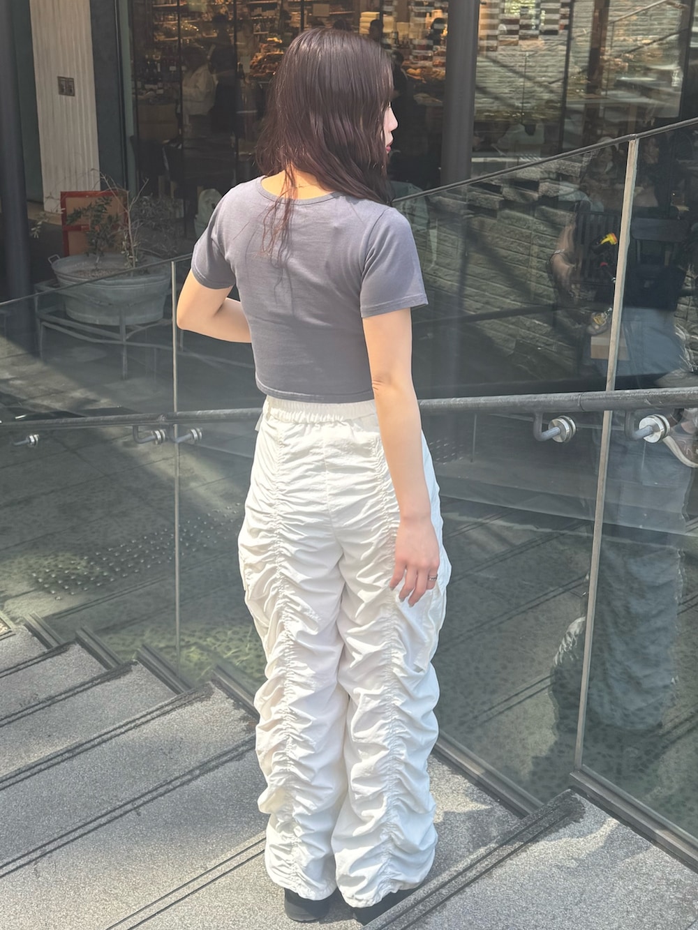 グレー系のTシャツ/カットソー、ホワイト系のその他パンツ、ブラック系のブーツを着用したレディースの春コーディネートの3枚目の写真