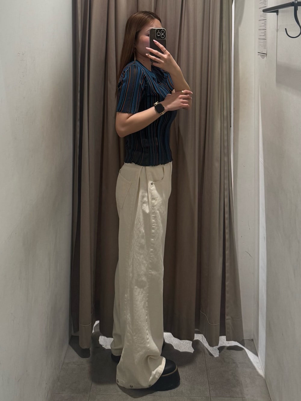 ホワイト系のデニムパンツ、ブルー系のニット/セーター、ブラック系のブーツを着用したレディースの春コーディネートの2枚目の写真