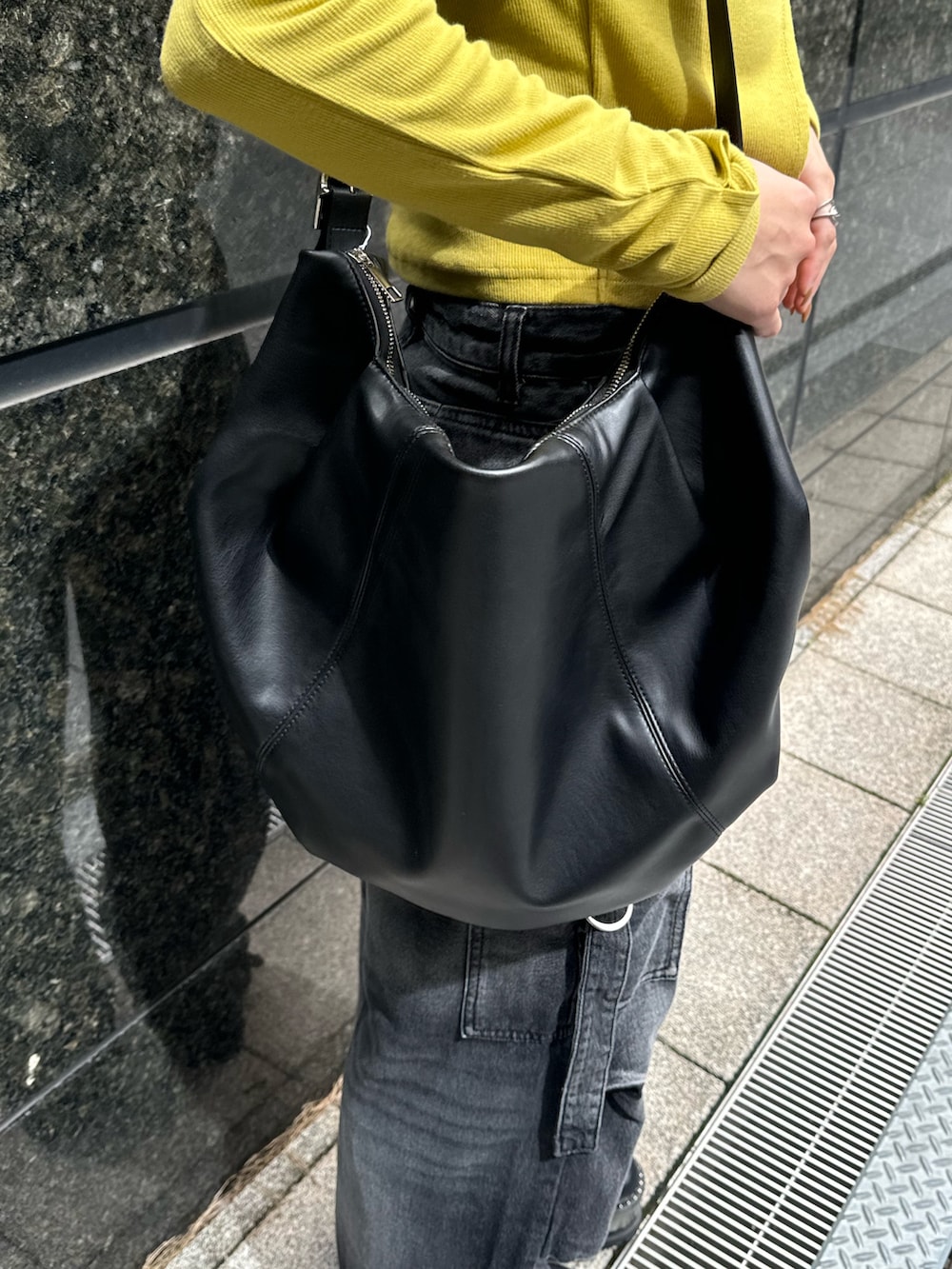 イエロー系のTシャツ/カットソー、ブラック系のデニムパンツ、ブラック系のブーツを着用したレディースの秋コーディネートの10枚目の写真