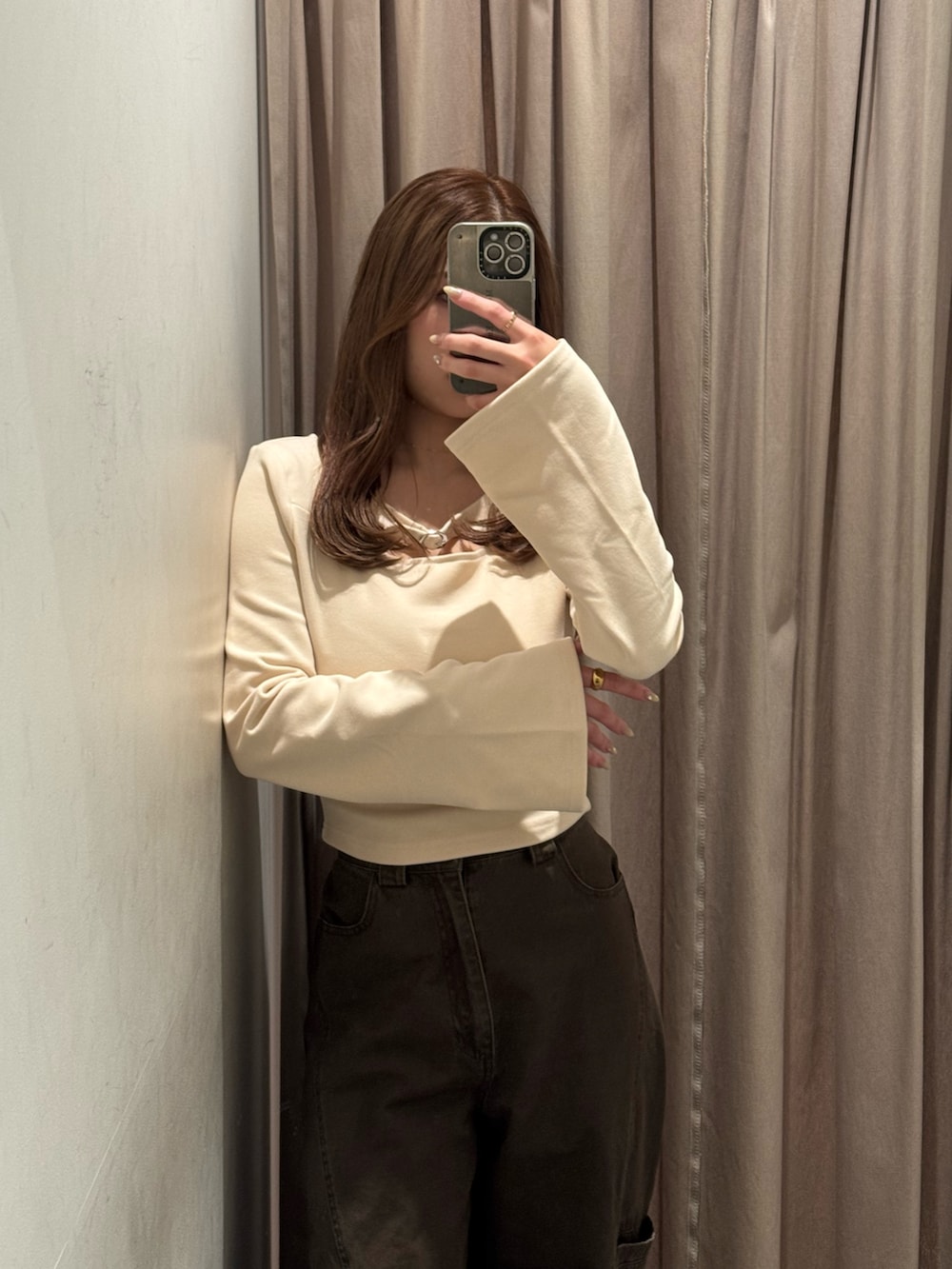 ブラウン系のその他パンツ、ホワイト系のTシャツ/カットソー、ブラック系のブーツを着用したレディースの冬コーディネートの4枚目の写真