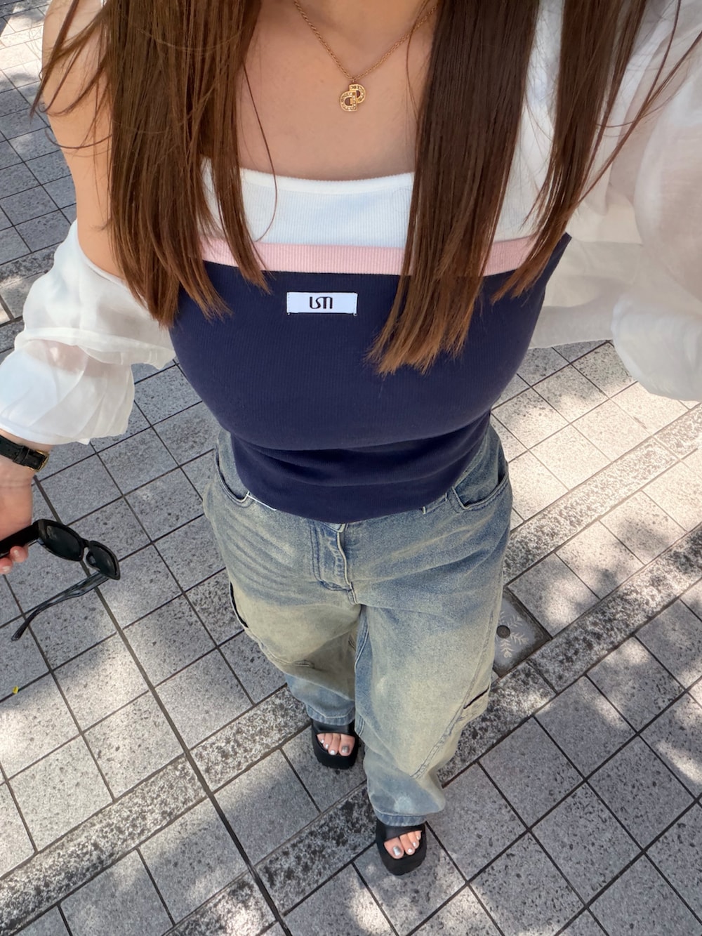 ブルー系のデニムパンツ、ブルー系のタンクトップ、ホワイト系のシャツ/ブラウスを着用したレディースの春コーディネートの4枚目の写真