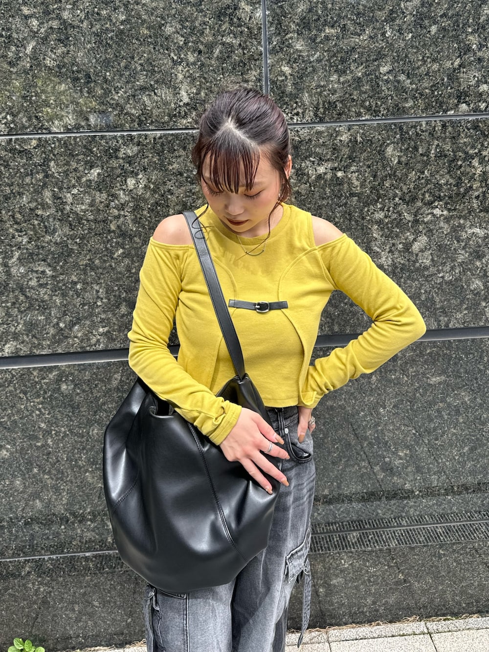 イエロー系のTシャツ/カットソー、ブラック系のデニムパンツ、ブラック系のブーツを着用したレディースの秋コーディネートの5枚目の写真