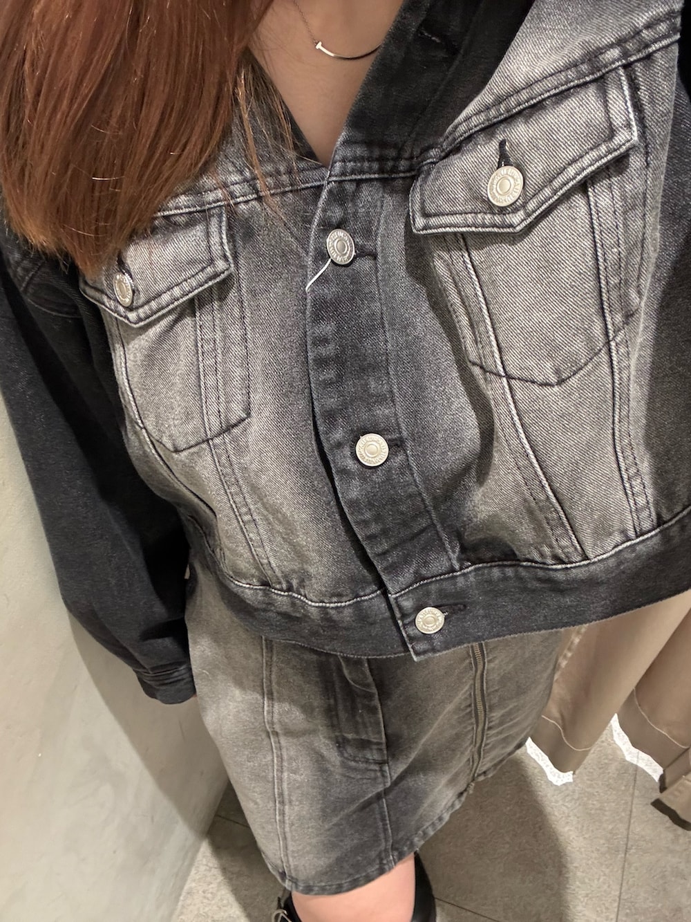 ブラック系のデニムジャケット、ブラック系のデニムスカート、ブラック系のブーツを着用したレディースの冬コーディネートの5枚目の写真