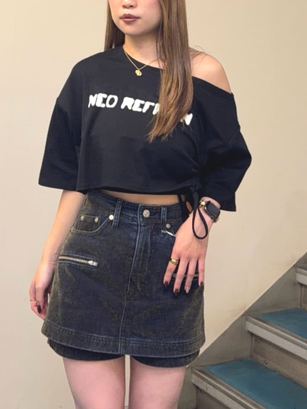 ブラック系のブーツ、ブラック系のTシャツ/カットソー、グリーン系のデニムスカートを着用したレディースの夏コーディネートの4枚目の写真