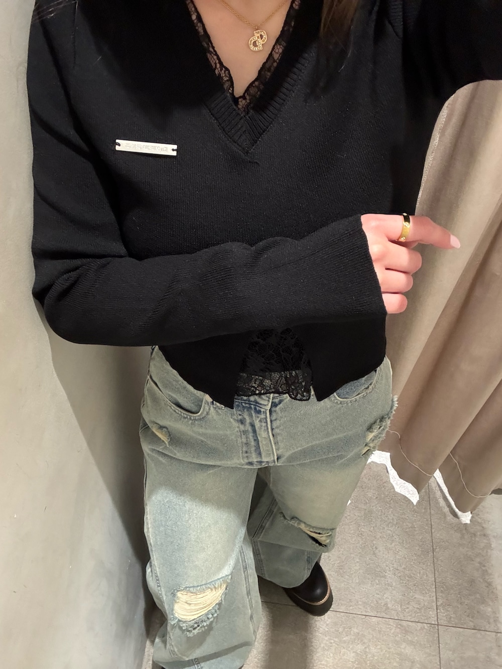 ブルー系のデニムパンツ、ブラック系のニット/セーター、ブラック系のブーツを着用したレディースの春コーディネートの5枚目の写真