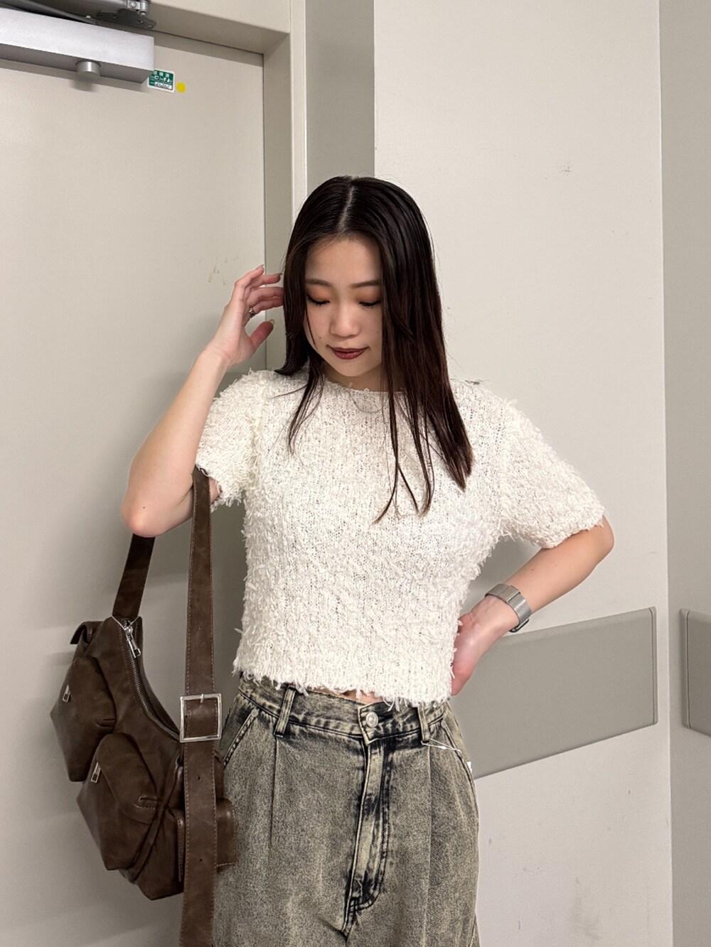 ホワイト系のニット/セーター、ブラック系のデニムパンツ、ブラック系のブーツを着用したレディースの春コーディネートの4枚目の写真