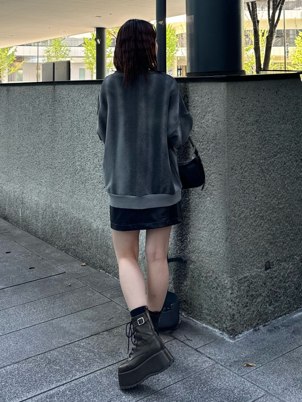 グレー系のスウェット、ブラック系のスカート、ブラック系のハンドバッグを着用したレディースの秋コーディネートの3枚目の写真
