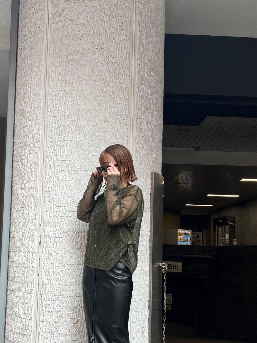 グリーン系のTシャツ/カットソー、ブラック系のスカートを着用したレディースの冬コーディネートの4枚目の写真