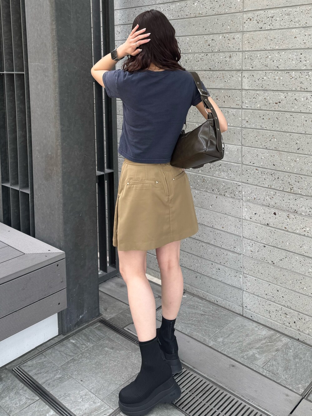 ブルー系のTシャツ/カットソー、ベージュ系のスカート、ブラック系のブーツを着用したレディースの春コーディネートの3枚目の写真