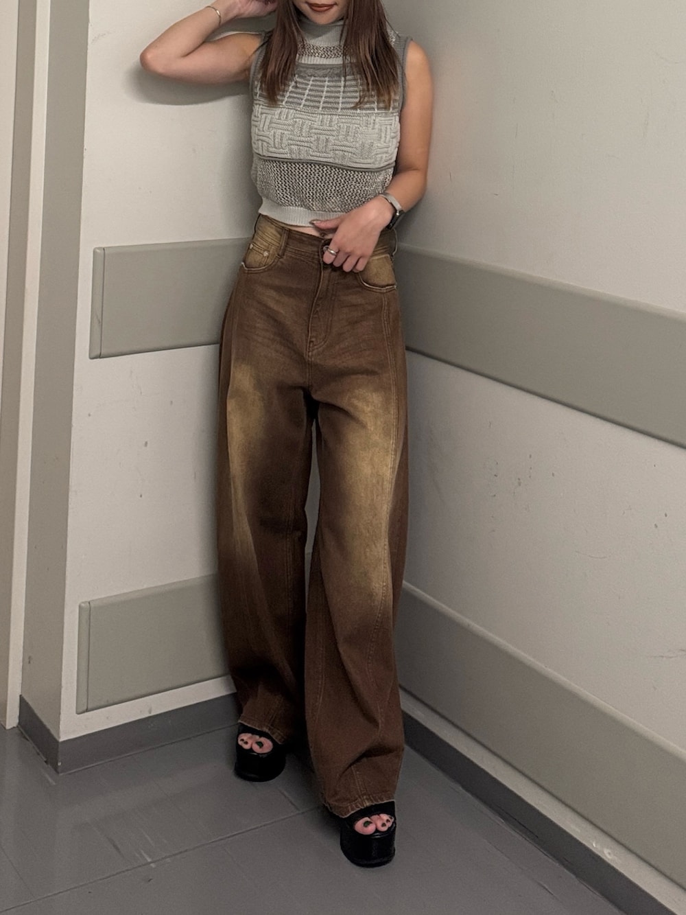 グレー系のタンクトップ、ブラウン系のデニムパンツ、ブラック系のサンダルを着用したレディースの夏コーディネートの6枚目の写真