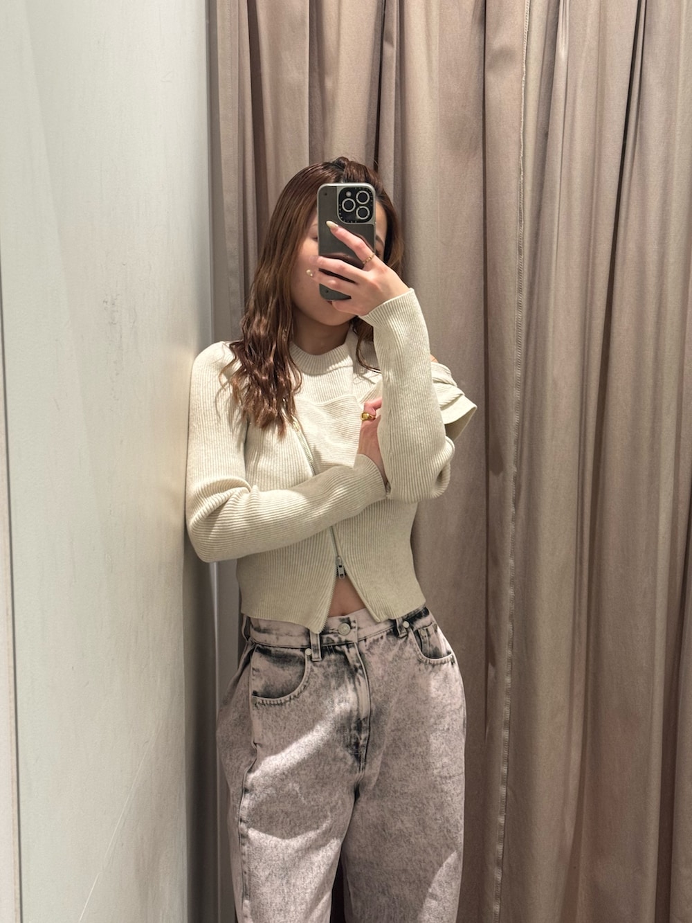 ピンク系のデニムパンツ、ホワイト系のニット/セーター、ブラック系のブーツを着用したレディースの冬コーディネートの4枚目の写真