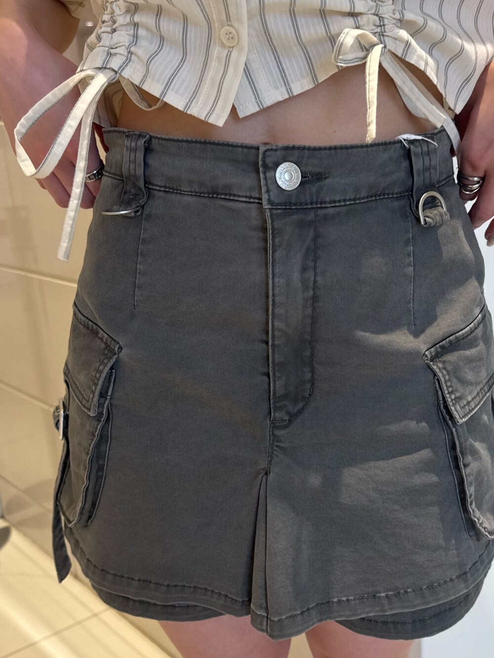 ホワイト系のシャツ/ブラウス、グレー系のスカート、ブラック系のブーツを着用したレディースの春コーディネートの7枚目の写真