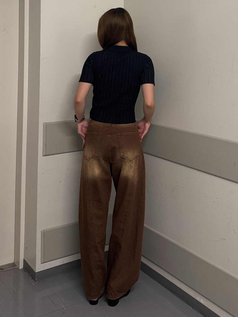 ブラック系のニット/セーター、ブラウン系のデニムパンツ、ブラック系のサンダルを着用したレディースの夏コーディネートの3枚目の写真