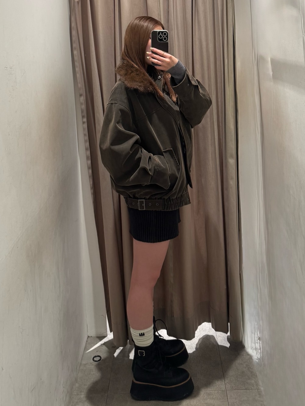 ブラウン系のブルゾン、ブラック系のその他パンツ、ブラック系のブーツを着用したレディースの冬コーディネートの2枚目の写真