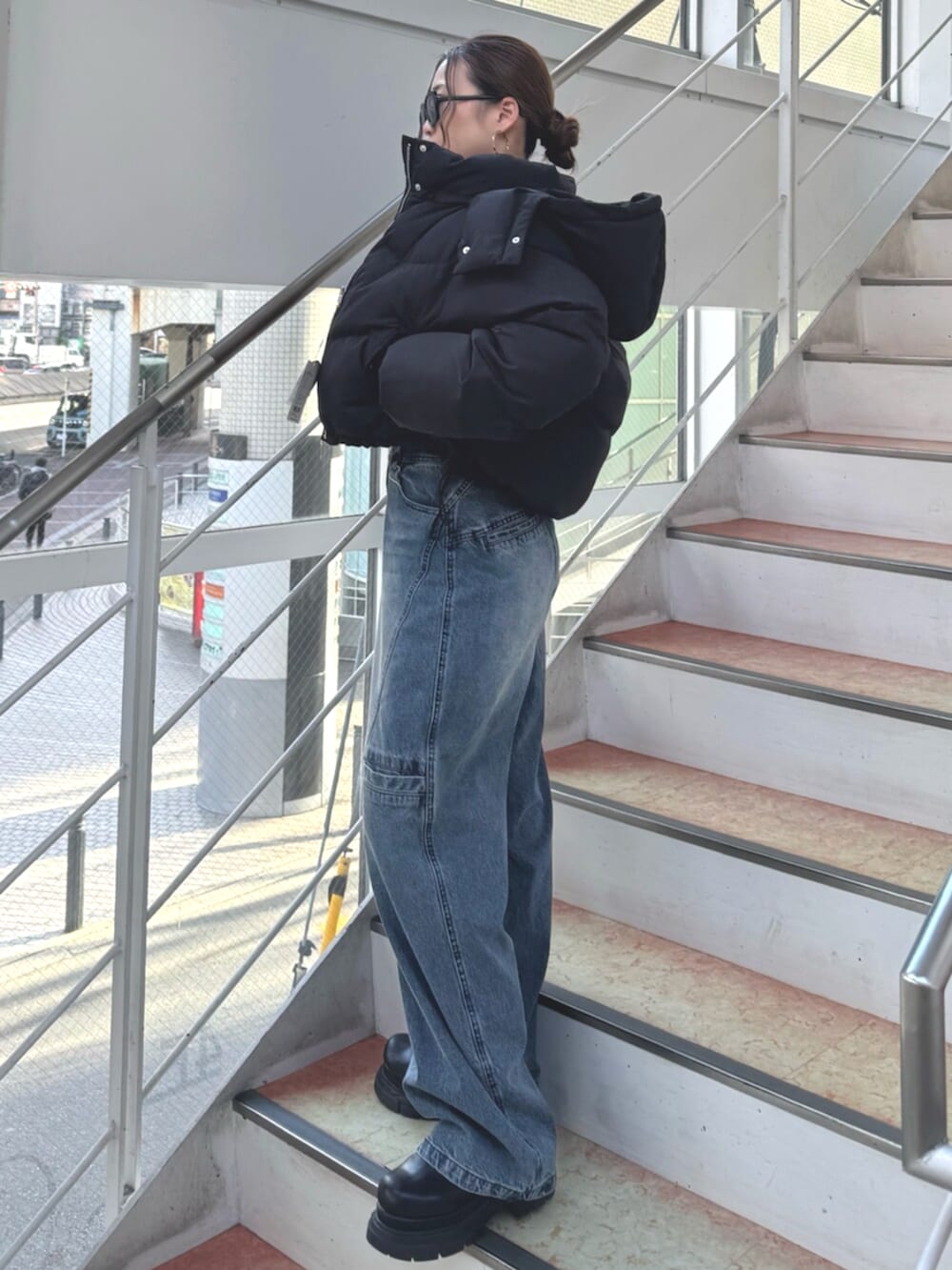 ブラック系のブーツ、ブルー系のデニムパンツ、レッド系のニット/セーターを着用したレディースの冬コーディネートの2枚目の写真