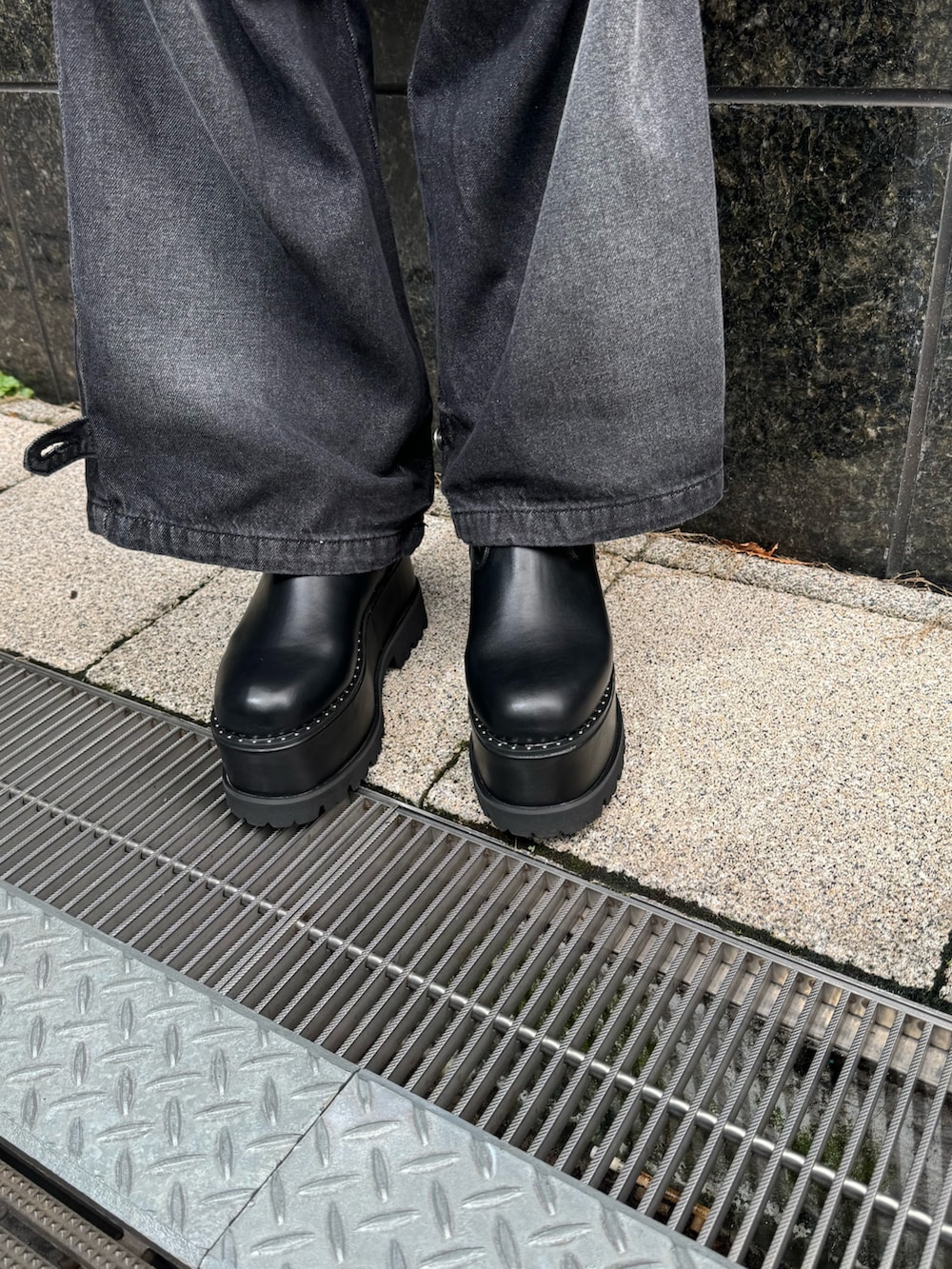 イエロー系のTシャツ/カットソー、ブラック系のデニムパンツ、ブラック系のブーツを着用したレディースの秋コーディネートの9枚目の写真