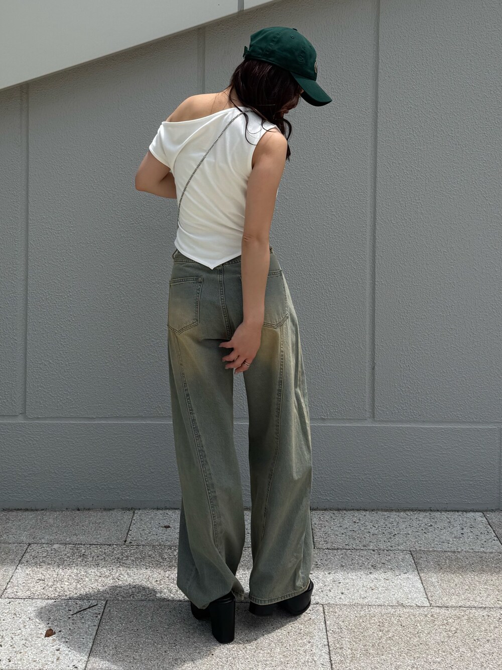 ブルー系のデニムパンツ、ホワイト系のTシャツ/カットソー、ブラック系のサンダルを着用したレディースの夏コーディネートの3枚目の写真