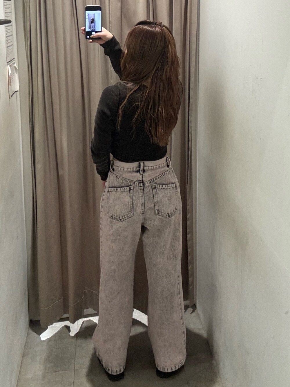 ピンク系のデニムパンツ、ブラック系のTシャツ/カットソー、ブラック系のブーツを着用したレディースの冬コーディネートの3枚目の写真