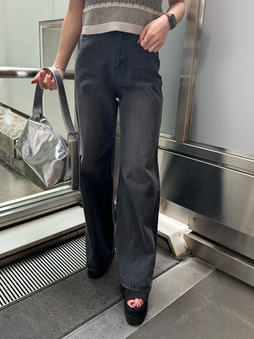 グレー系のニット/セーター、ブラック系のデニムパンツを着用したレディースの春コーディネートの10枚目の写真