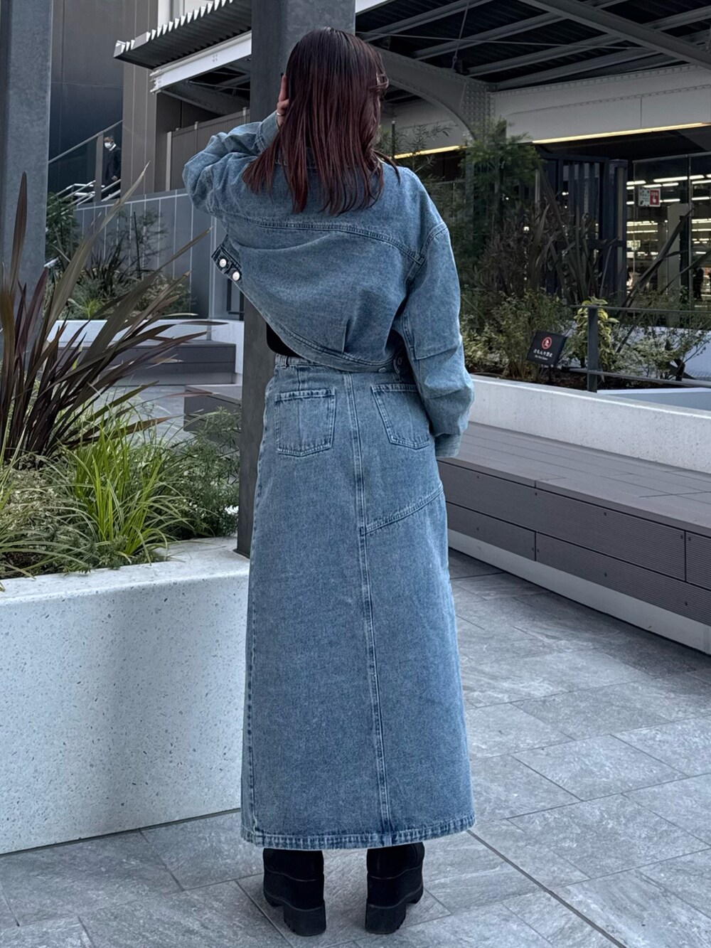ブルー系のデニムスカート、ブルー系のデニムジャケット、ブラック系のニット/セーターを着用したレディースの冬コーディネートの4枚目の写真