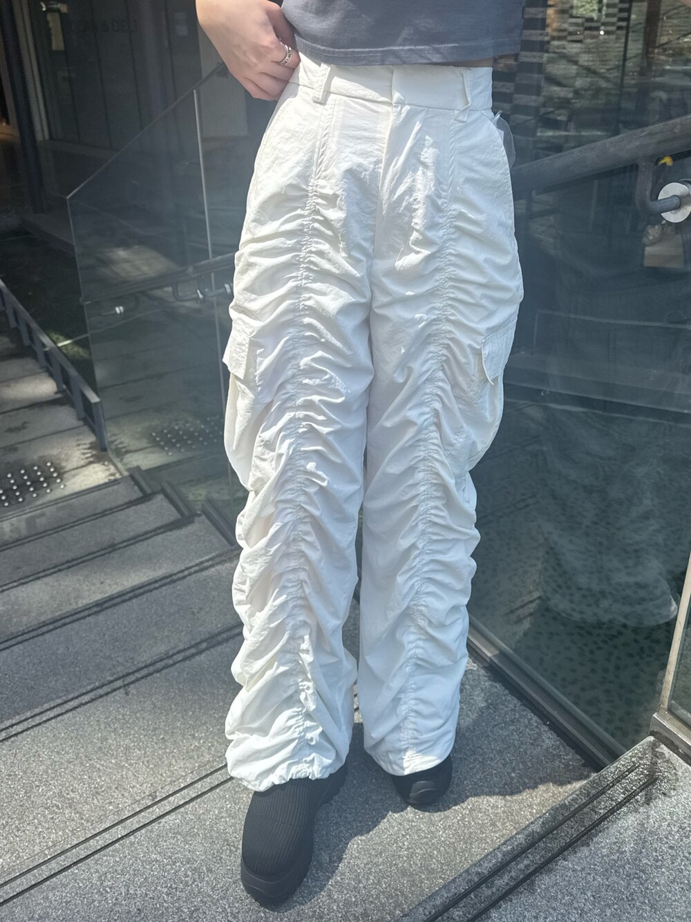 グレー系のTシャツ/カットソー、ホワイト系のその他パンツ、ブラック系のブーツを着用したレディースの春コーディネートの6枚目の写真