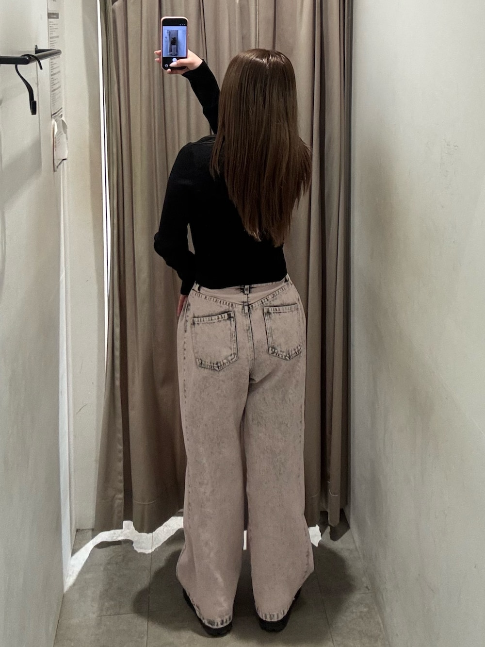 ピンク系のデニムパンツ、ブラック系のニット/セーター、ブラック系のブーツを着用したレディースの春コーディネートの3枚目の写真