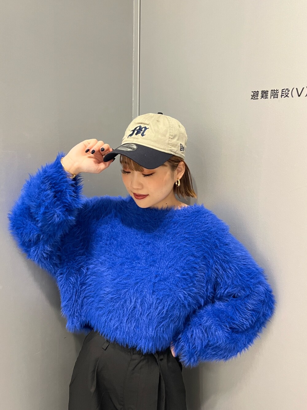 ブルー系のニット/セーター、ブラック系のその他パンツ、ブラック系のブーツを着用したレディースの秋コーディネートの4枚目の写真