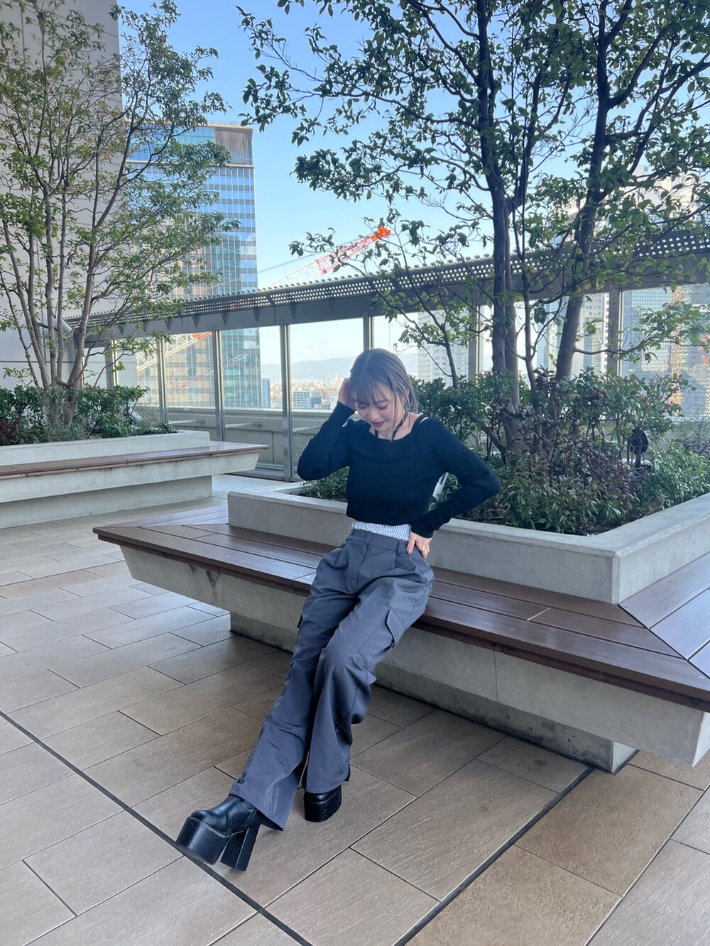 ブラック系のニット/セーター、グレー系のその他パンツを着用したレディースの春コーディネートの2枚目の写真