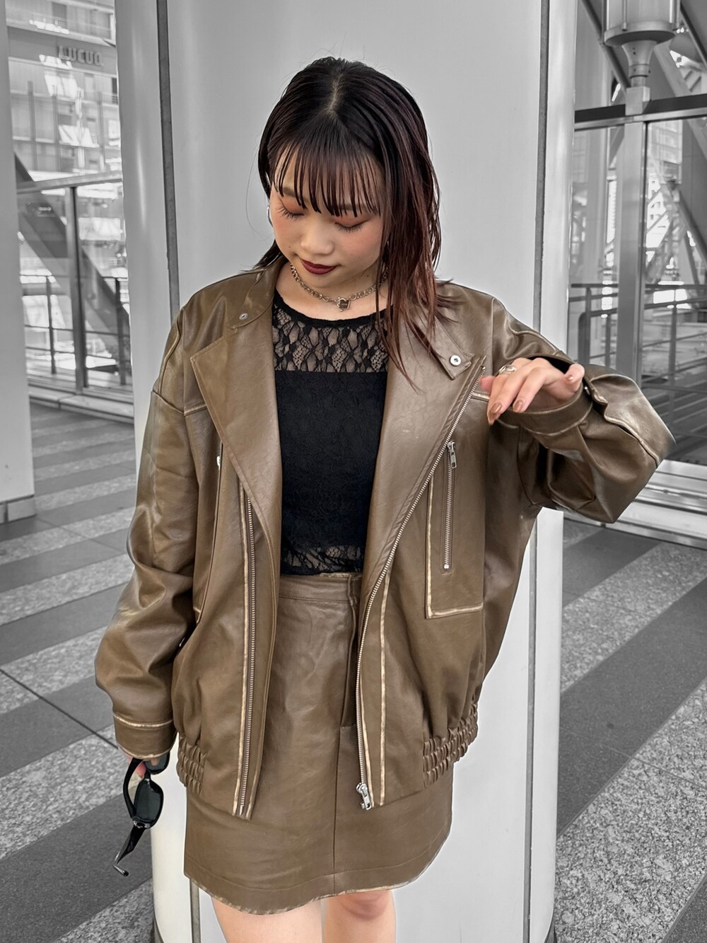 ブラック系のTシャツ/カットソー、ブラウン系のライダースジャケット、ブラウン系のスカートを着用したレディースの秋コーディネートの5枚目の写真