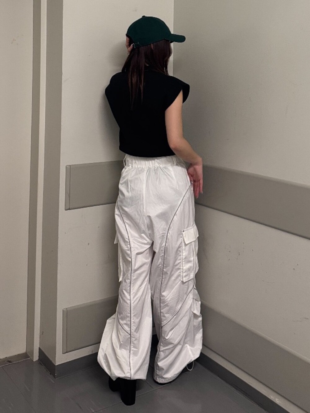 ホワイト系のカーゴパンツ、ブラック系のニット/セーター、ブラック系のサンダルを着用したレディースの春コーディネートの3枚目の写真