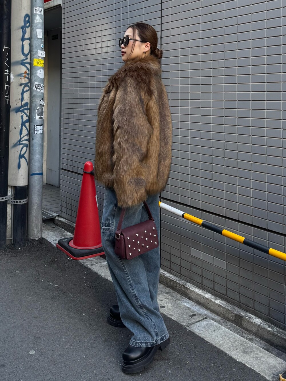 ブルー系のデニムパンツ、レッド系のニット/セーター、ブラウン系のその他アウターを着用したレディースの冬コーディネートの2枚目の写真