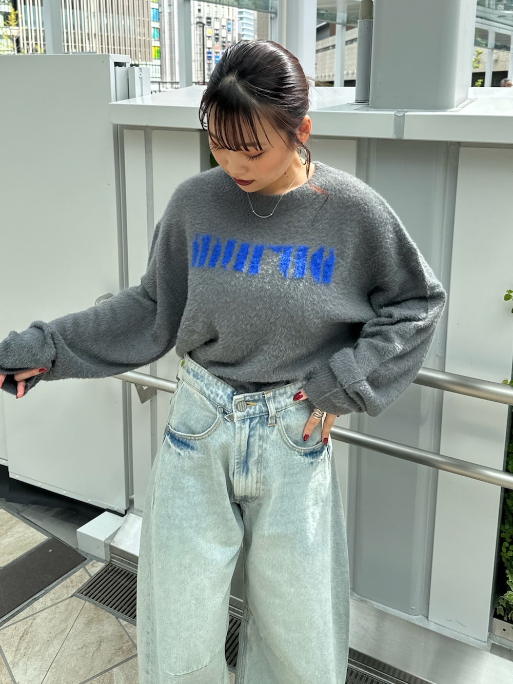 グレー系のニット/セーター、ブルー系のデニムパンツ、ブラウン系のブーツを着用したレディースの秋コーディネートの4枚目の写真