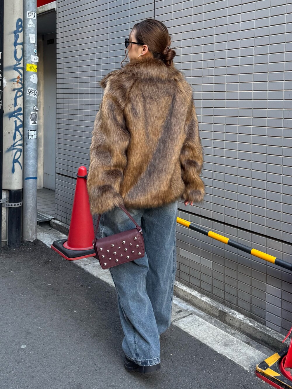 ブルー系のデニムパンツ、レッド系のニット/セーター、ブラウン系のその他アウターを着用したレディースの冬コーディネートの3枚目の写真